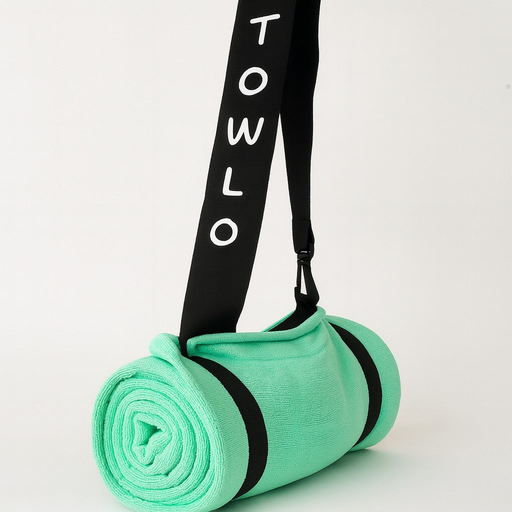 Towlo mint green roll-up beach towel with built-in pillow and black branded shoulder strap, sand-free cotton towel product photo on white background